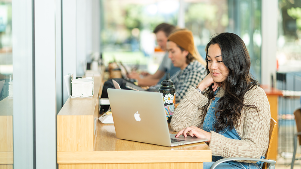 person at table with macbook