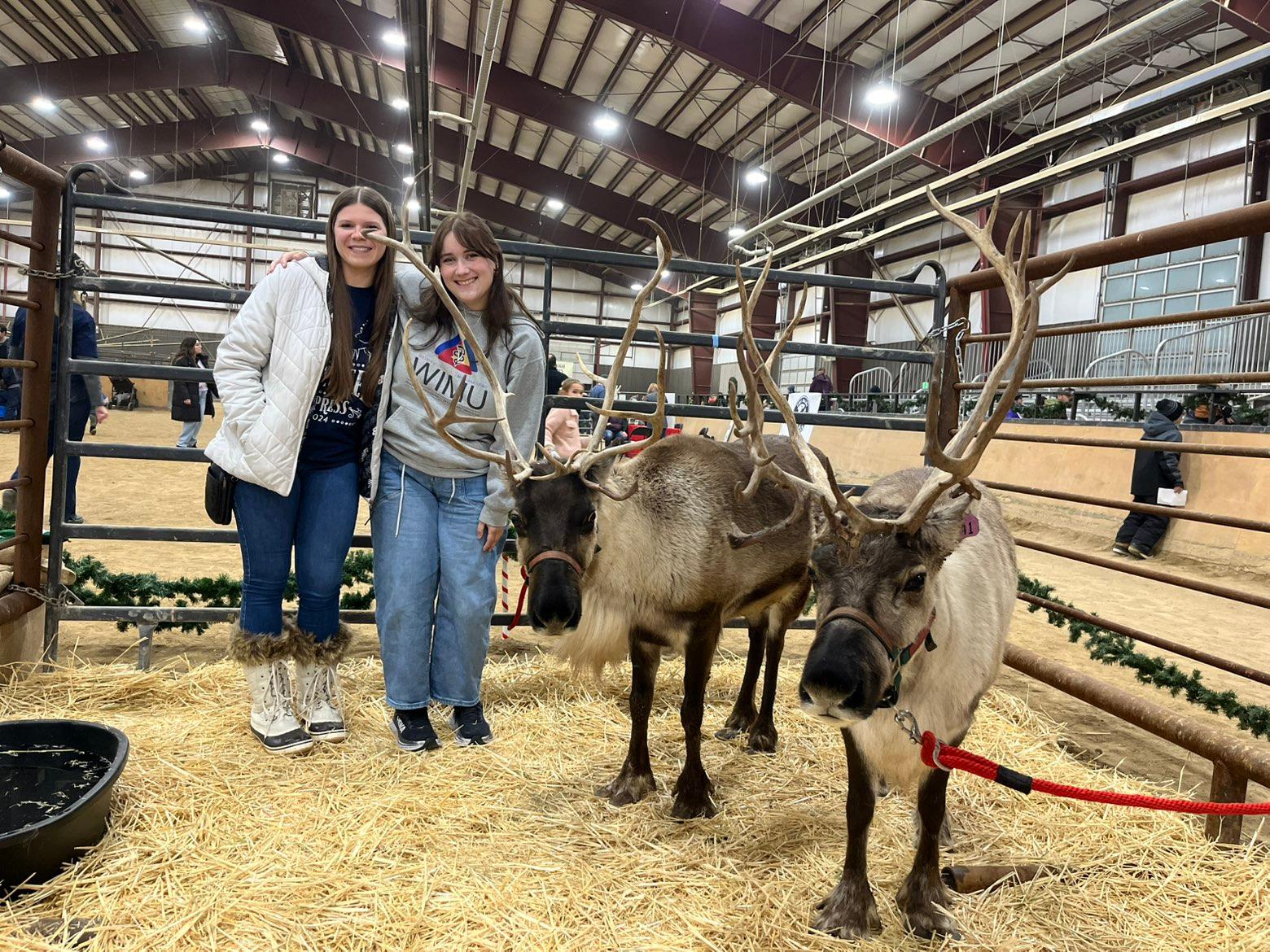 Mikayla and Austin pose next to the reindeer at the Reindeer Express.