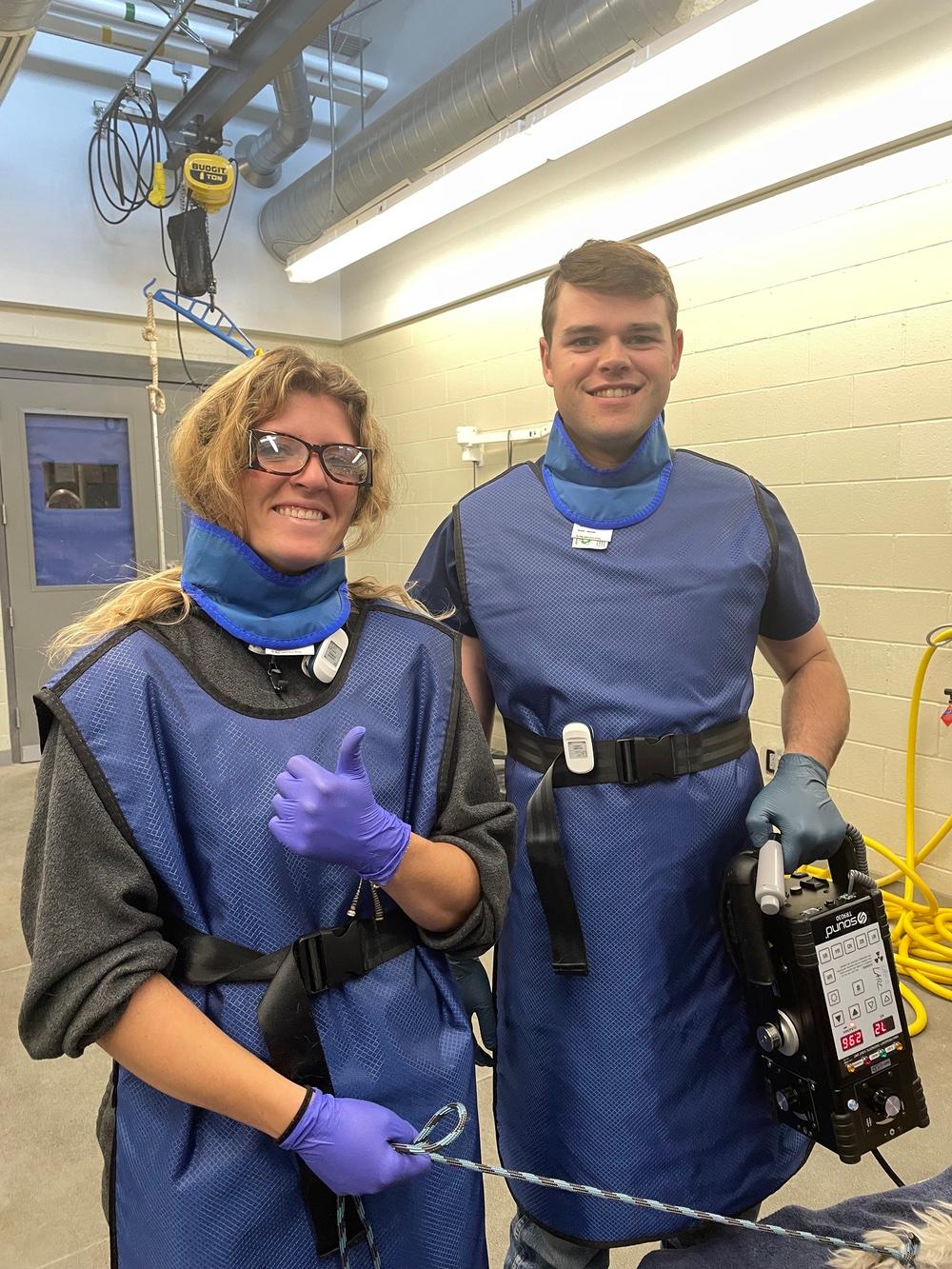 First-year students Chance and Addy wear personal protective equipment for radiographs at the USU Animal Science Farm.